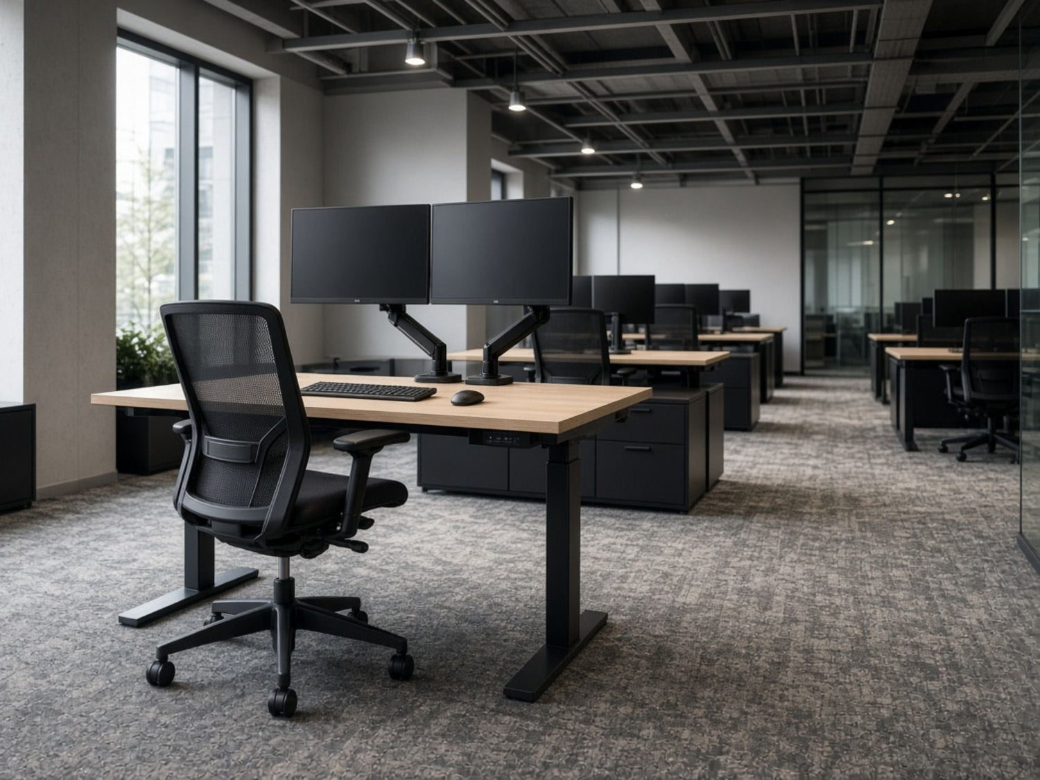 Open office with dual-monitor workstations and adjustable-height desks