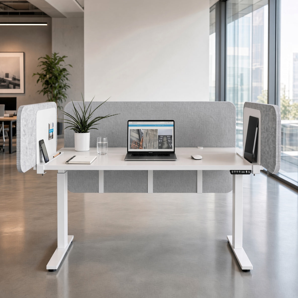 Gray magnetic desk dividers holding a phone and tablet on a white sit-stand desk in an open office